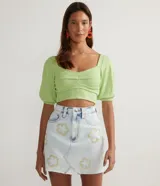 Blusa cropped de tejido acanalado color verde claro, con escote cuadrado, mangas cortas abullonadas y pliegues en el busto.