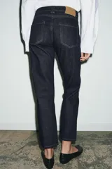 Jeans de tiro medio color beige, corte cigarette, con cinco bolsillos y cierre frontal de cremallera y botón.