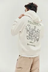 Canguro color crema con capucha, bolsillo tipo canguro y puños y bajo acanalados. Estampado frontal con texto "Palermo's We Assured Restaurant Palermo".