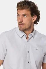 Camisa de hombre a rayas finas color rosa y blanco, de manga corta, con cuello abotonado, bolsillo en el pecho con logo bordado y botones personalizados. Confeccionada 100% en algodón.