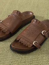 Sandalia negra de cuero vacuno con tiras anchas y suela elevada. Diseño calado en la capellada diseñado por Jazmin Chebar.