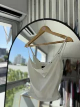 Top blanco de breteles finos con escote drapeado y detalle de frunces en los laterales.