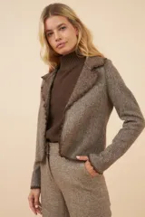 Chaqueta color crudo de lana fina sin teñir, de corte recto con cuello solapa y mangas 3/4.