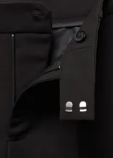 Pantalón de vestir azul marino, de corte recto, con bolsillos laterales y traseros. Se ajusta a la cintura con cinturón de cuero marrón.