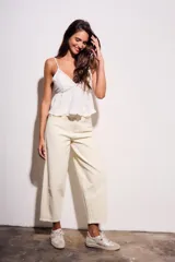 Jean de mujer color crema o blanco roto, de corte baggy y tiro medio. Confeccionado en algodón con un pequeño porcentaje de elastano.