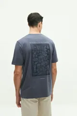 Remera blanca de manga corta con cuello redondo y estampado pequeño en el pecho con una columna griega y texto en color celeste.