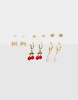 Set de seis pares de aros dorados con diferentes diseños: perlas, moños, corazones, bolitas y cerezas.