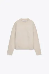 Sweater color beige de punto liso, con cuello redondo y mangas largas con terminación en rib.