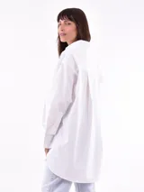 Camisa blanca oversize de manga larga con cuello clásico y bolsillo en el pecho.