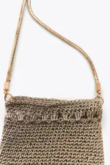 Bolso mini tipo saco confeccionado con hilo metalizado color dorado en forma de malla. Detalle de flecos metálicos labrados. Asa tipo cordón metálica.