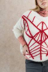 Sweater de mohair color crema con diseño de telaraña bordado a mano en negro.