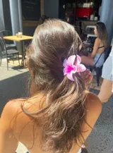 Pinza para el cabello en forma de flor color fucsia, ideal para adornar peinados.