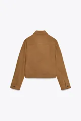 Cazadora color marrón de cuello solapa y manga larga acabada en puño con botón. Bolsillos de vivo en delantero, detalle de costuras marcadas, forro interior combinado a contraste y cierre frontal con cremallera y gancho metálico oculto.