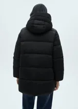 Campera puffer color beige con capucha, cierre frontal con cremallera y bolsillos laterales.