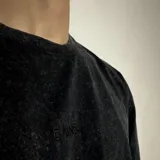 Remera gris con efecto stone wash, corte clásico, cuello redondo y manga corta. Estampado frontal pequeño con la palabra 'GAINS.' en color blanco.