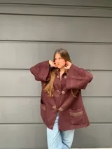 Saco capa bordo de lana con cierre de broches tipo duffle coat y mangas anchas con detalle de tejido trenzado.