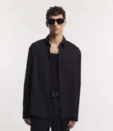 Camisa negra de poliéster con cuello inglés, manga larga, abotonada adelante y textura con rayas verticales.