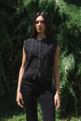 Chaleco tejido negro con botones en la delantera y diseño de punto acanalado.