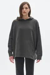 Buzo canguro con capucha color gris oscuro, de corte oversized y confeccionado en algodón lavado.