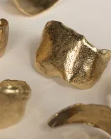 Brazalete rígido plateado con textura irregular.