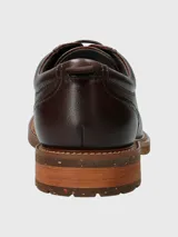 Zapato acordonado de cuero color marrón claro, con suela de goma y detalle de tirador en el talón.