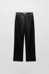 Pantalón de tiro alto símil cuero, corte bootcut, con cintura con trabillas, cinco bolsillos y cierre frontal con cremallera y botón.