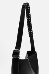 Bolso tipo shopper color negro, con compartimento principal con cierre mediante imán y bolsillo plano interior. Asa de hombro ajustable.