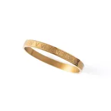 Brazalete rígido dorado con números romanos grabados.