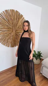 Vestido largo negro de tejido de punto con escote recto y breteles finos. La falda es de encaje transparente. Incluye una bufanda fina al tono.