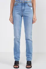 Pantalón de jean celeste con corte recto, tiro alto, detalles de roturas en las rodillas y cadena dorada decorativa en la cintura.