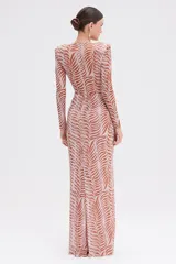 Vestido largo de fiesta con estampado abstracto en tonos marrones y rosados. Tiene escote en V profundo, mangas largas con hombreras y drapeado en la cintura.