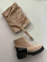 Bota de cuero color marrón oscuro, con caña media arrugada y hebilla lateral.