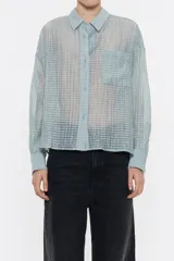 Camisa rosa con rayas horizontales, de corte holgado, manga larga con puños abotonados, cuello camisero, cierre frontal con botones, bolsillo de parche en el pecho y canesú en la espalda con pliegue.
