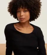 Pijama largo de dos piezas: blusa de canalé negra de manga larga y pantalón de viscosa con estampado de leopardo y lazos en las perneras.