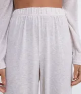 Conjunto de pijama largo en tejido de punto color gris claro. Incluye una remera de manga larga con cuello en V, botones frontales y lazo en la cintura, y un pantalón largo con cintura elástica y puños ajustados.