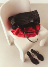 Bolso tipo shopper negro de fibras naturales trenzadas, con doble asa corta de cuero sintético.