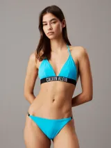Conjunto de bikini Calvin Klein color celeste, compuesto por un corpiño triangular con tiras finas y banda elástica con el logo de la marca, y una bombacha clásica con cintura baja y laterales finos.