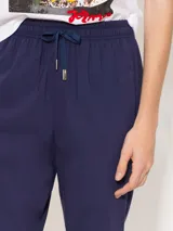 Pantalón babucha color café, confeccionado en algodón liviano, con cintura elastizada, cordón ajustable, bolsillos laterales y botamangas levemente entalladas.