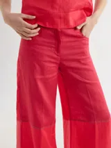 Pantalón ancho de corte recto con distintos cortes combinando colores beige, negro y marrón.