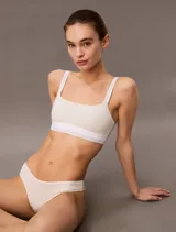 Corpiño Calvin Klein color beige, de breteles anchos y corte deportivo. Elástico con logo de la marca en el contorno inferior.