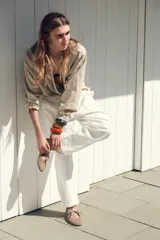 Zapato plano tipo bailarina color beige, de serraje, con puntera redondeada, suela plana y cierre con cordones.