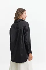 Camisa negra de manga larga confeccionada en tela satinada.