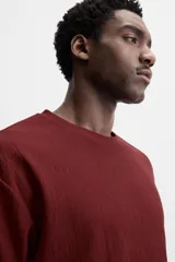 Camiseta negra de corte holgado, con cuello redondo y mangas cortas.