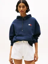 Buzo azul marino amplio con capucha y cordón distintivo, bolsillo canguro, puños y bajo de punto canalé, logo oversize de Tommy Hilfiger en la manga y la parte trasera, parche con logo de Tommy Hilfiger en el pecho y detalles distintivos de Hilfiger Sailing.