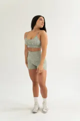Top deportivo negro con breteles finos y diseño texturizado.