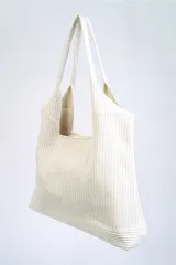 Bolso negro tipo tote bag con textura acanalada y asas de hombro.