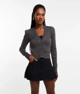 Cardigan gris de punto texturizado con escote en V, manga larga y cierre frontal abotonado.