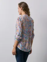 Blusa de gasa estampada con cuello a la base, escote en V y botones. Delantera con detalle plisado y largo de manga regulable con presilla y botón.