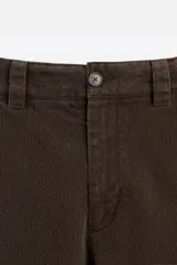 Pantalón marrón de pana, corte recto, con bolsillos laterales y traseros.