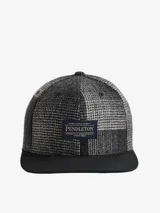 Gorra de seis paneles con visera plana, confeccionada en lana americana a cuadros en tonos grises y negros. Presenta un parche con el logo de Pendleton en el frente.